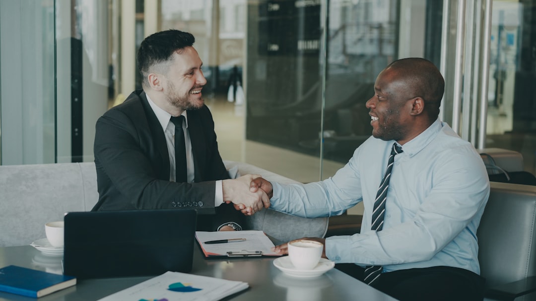 two businessmen shaking hands at corporate meeting
