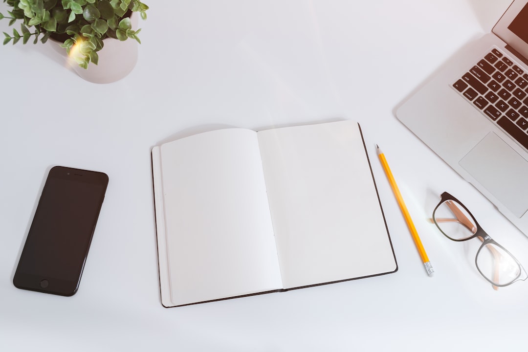 open notebook on white desk with laptop for content strategy
