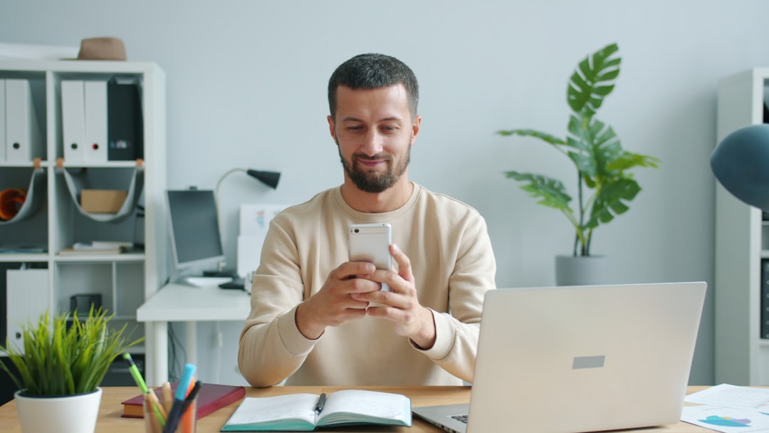 Man smiling while looking at his smartphone at his phone