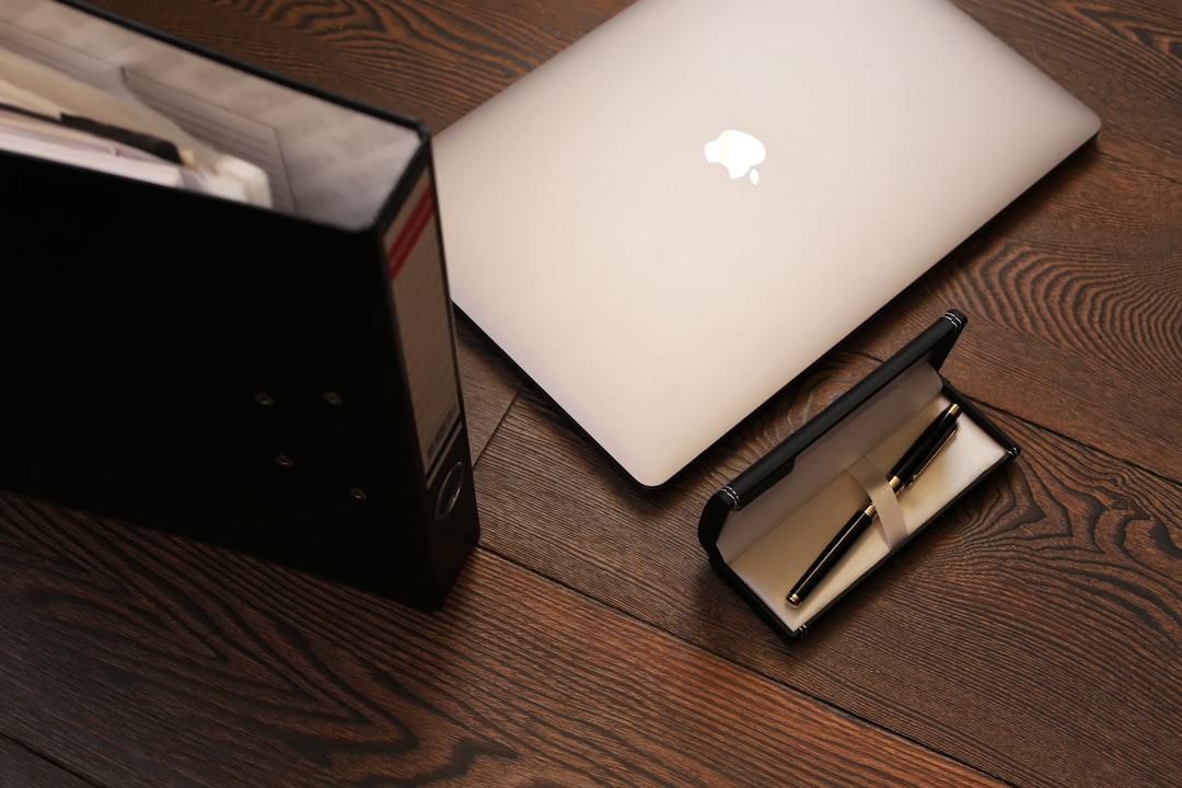 silver macbook on brown wooden table