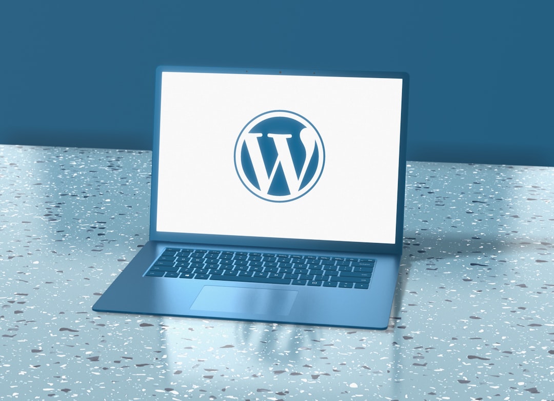 A blue laptop displaying the WordPress logo on a speckled blue surface