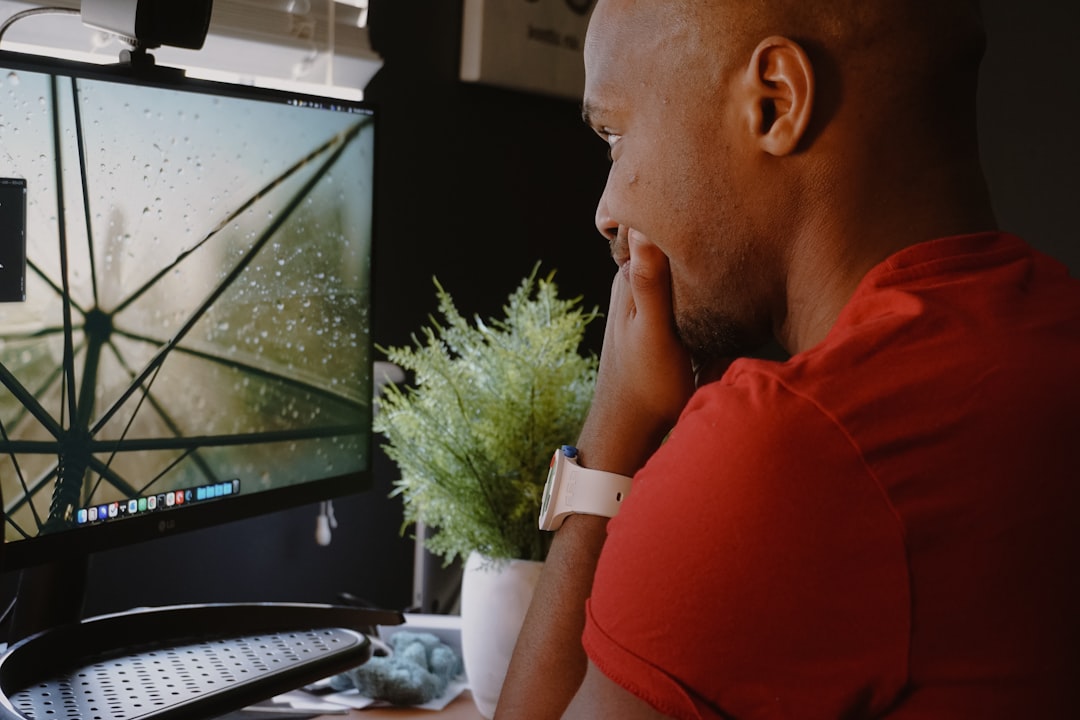 a man sitting in front of a computer monitor