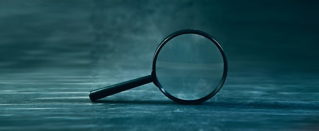 ルーペで印刷物の細部を確認している人の手元