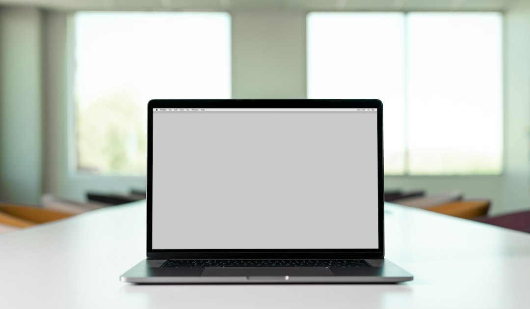 ノートパソコンでレンタルサーバーのお知らせを確認するWeb担当者