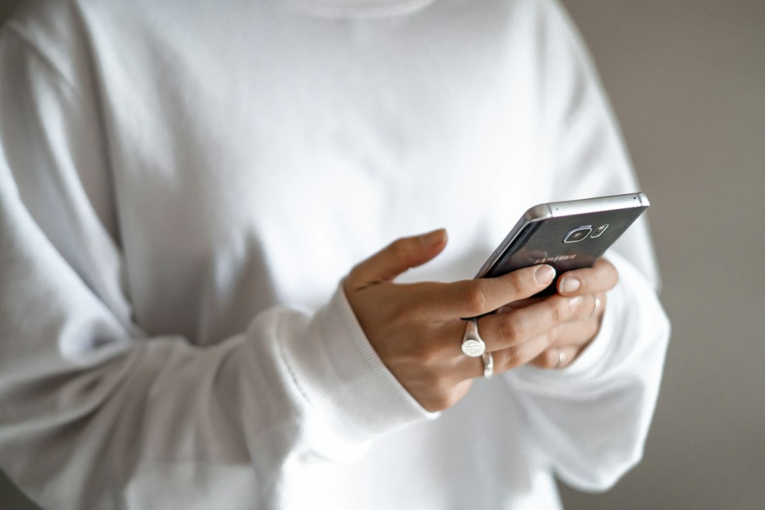 スマートフォンでメールを確認する人