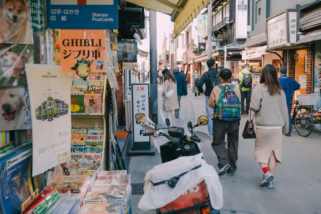 複数の言語のメニューが貼られた店先を見る外国人観光客
