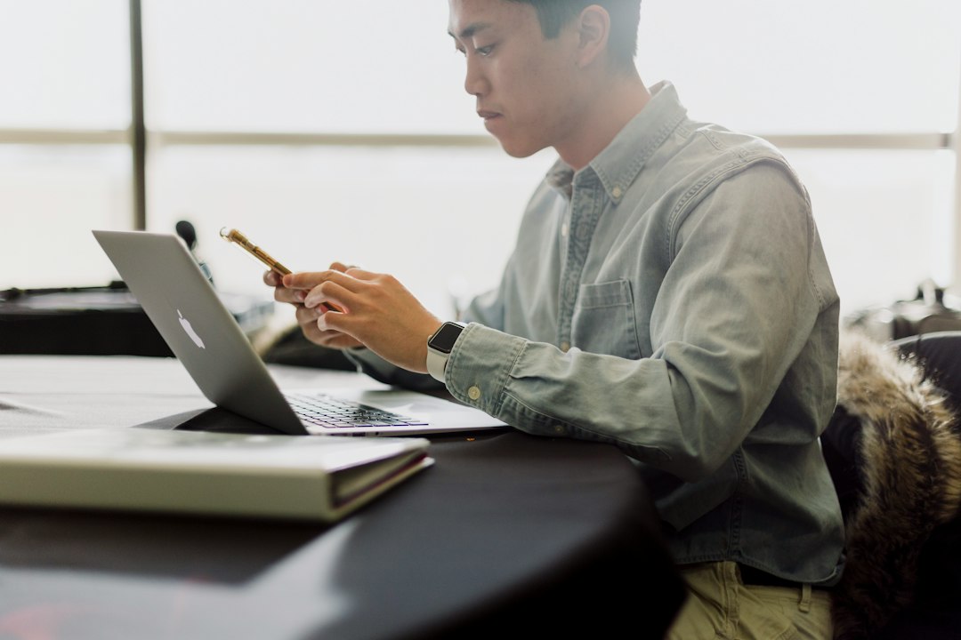 ノートパソコンでサーバー会社のお知らせを確認するWeb担当者
